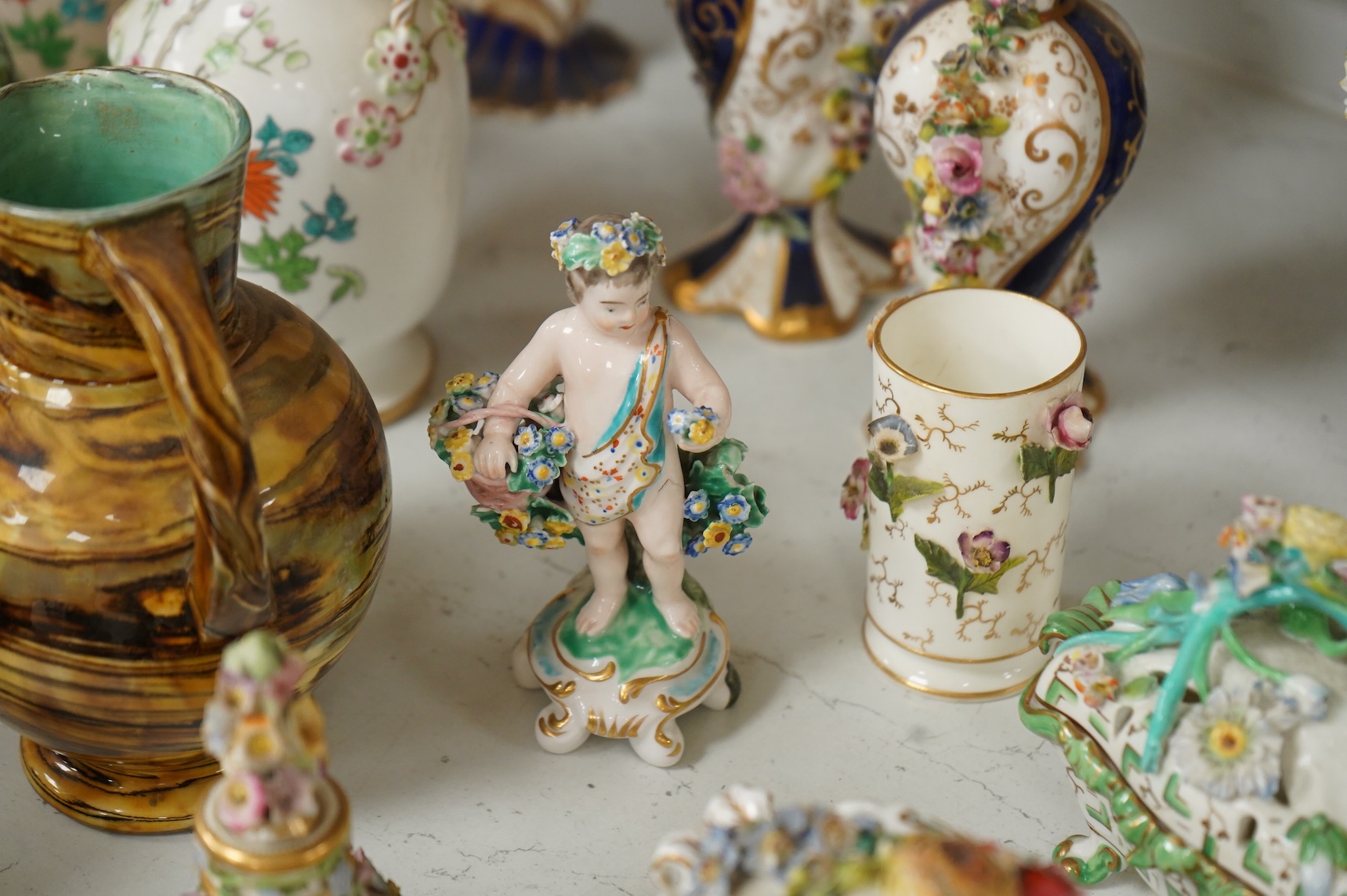 Large group of 19th/20th century English ceramics, to include a Rockingham basket, other English porcelain flower encrusted vessels, a Copeland and Garrett ewer, a Minton Sevres style beaker, a Wedgwood agate ware jug, R